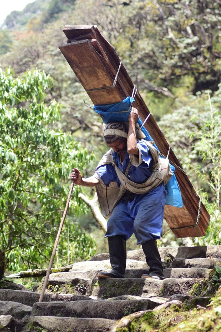 A porter climbing the stone staircase on the old trading trail to Ulleri